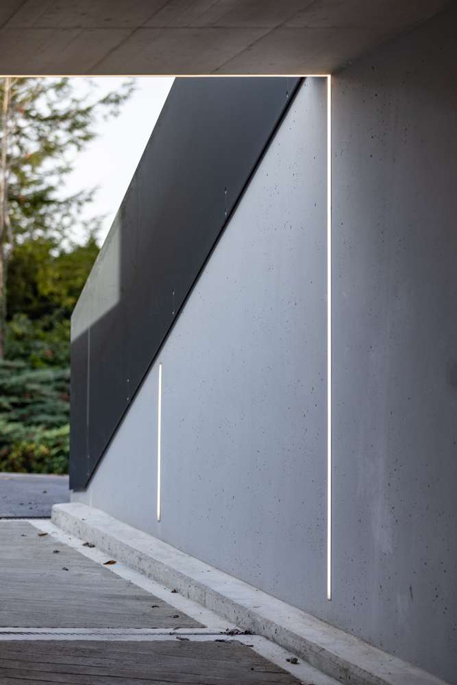 Detail der Einfahrt: Die Lichtlinie läuft über Wand und Decke in einem Zug, die schräge Blechverkleidung folgt der Rampe.
