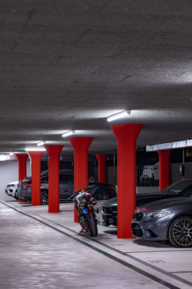 Die roten Pilzstützen der Einstellhalle – der Bestand, auf dem die beiden Häuser stehen.