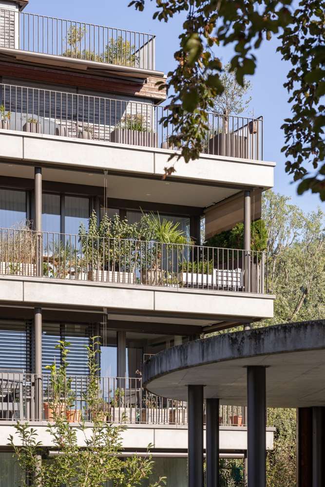 Balkonzone und Pavillon: Die Balkone liegen als zweite Schicht vor der Hülle, die Stützen aus Stahl; im Vordergrund das runde Betondach des Sitzplatzes.
