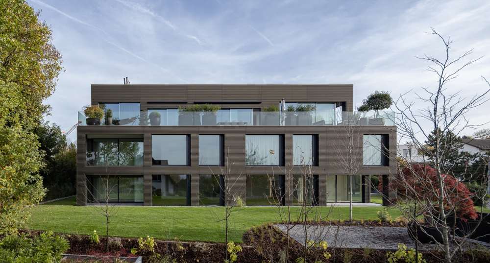 Gartenseite: geschosshohe Öffnungen in der Lochfassade, davor Loggien und Terrassen; das Penthouse tritt hinter der Glasbrüstung des Dachgartens zurück.